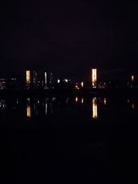 Illuminated cityscape against sky at night