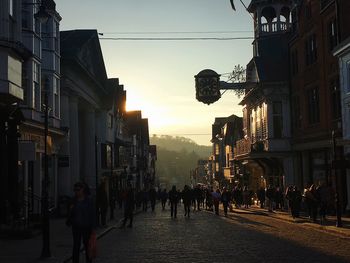 People walking on street amidst buildings in city