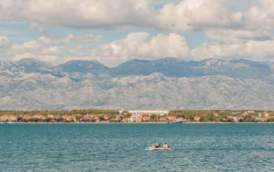 Boat on sea against mountains