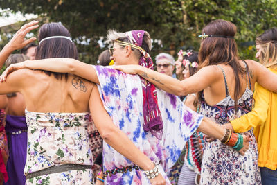 Rear view of friends dancing outdoors