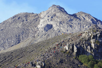 Mass climbing to the summit of mount merapi and the line of climbers on the track.