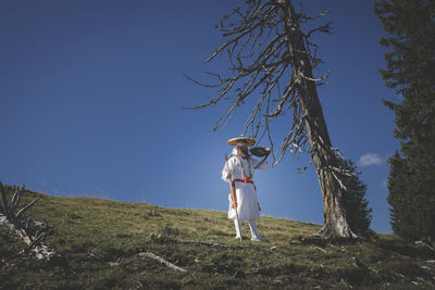 Full length of woman standing on land against sky