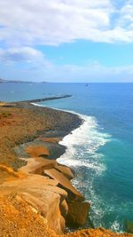 View of calm blue sea against cloudy sky