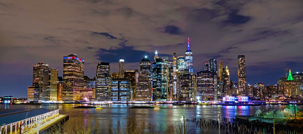 Illuminated buildings in city against sky at night