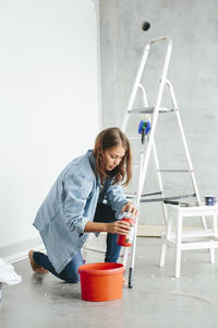 Young woman preparing paint for renovation