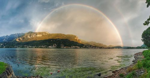 Scenic view of rainbow over lake against sky