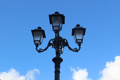 Low angle view of street light against blue sky