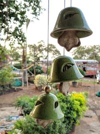 Close-up of old lamp hanging against trees