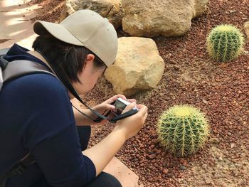 High angle view of woman photographing cactus
