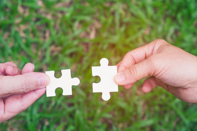 Close-up of hand holding paper against blurred background