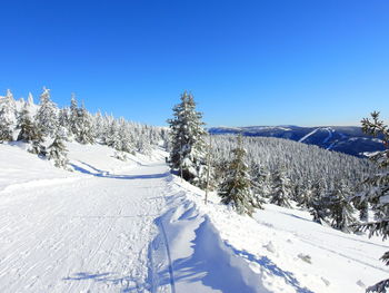 Scenic view of snowcapped mountains against clear blue sky