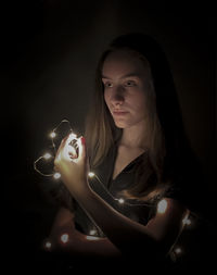 Portrait of a beautiful young woman over black background