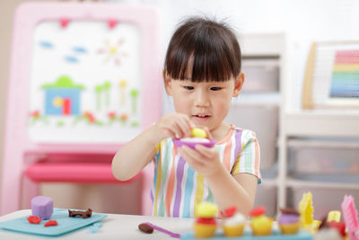 Cute girl playing with clay at home