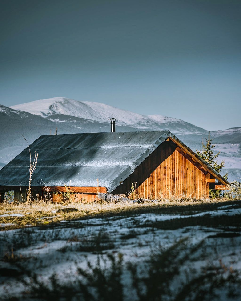 HOUSES BY SNOWCAPPED MOUNTAIN AGAINST SKY