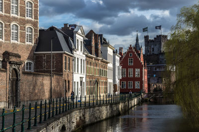 Canal amidst buildings against sky