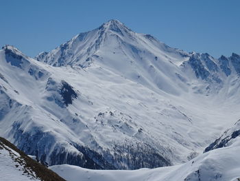 Scenic view of snow covered mountains against clear sky