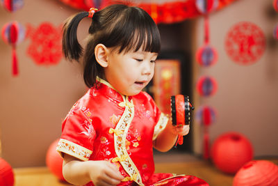 Close-up of cute girl holding red flowers