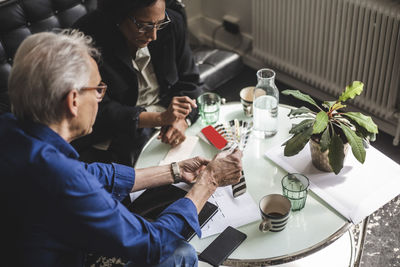 High angle view of male and female owners discussing at table in office