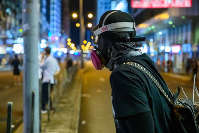 Man standing on city street at night