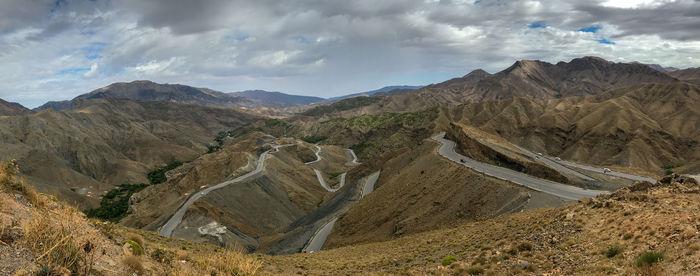 Amazing rocky atlas desert roads - panoramic view of landscape against cloudy sky