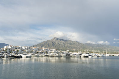 Sailboats moored on sea against sky