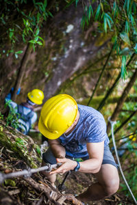 High angle view of men climbing in forest