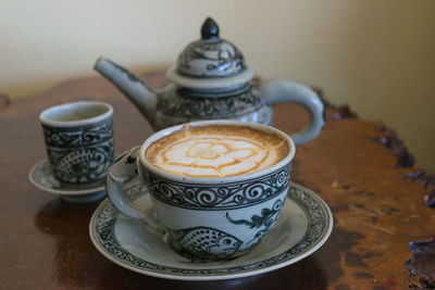 Close-up of coffee cup on saucer over table