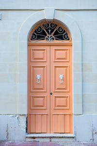 Traditional wooden, vintage painted orange door in malta