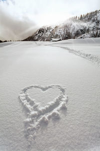 Heart shape on snow covered land