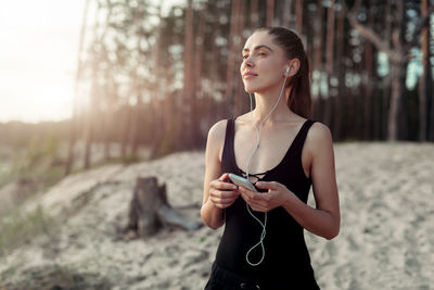 Young woman looking away while standing on land