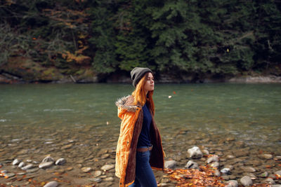 Young woman looking at waterfall in forest