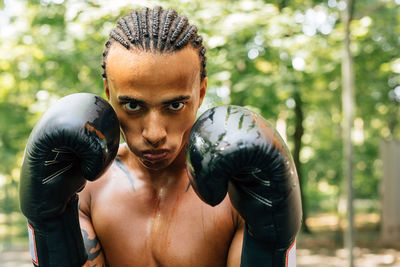 Portrait of shirtless man boxing on street