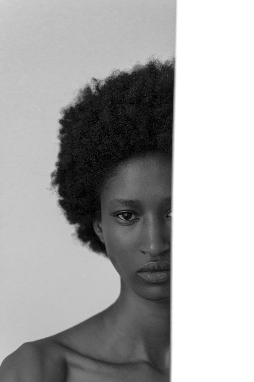 portrait, one person, hairstyle, human hair, headshot, young adult, afro, black and white, studio shot, adult, indoors, curly hair, women, looking at camera, front view, monochrome photography, white background, human face, close-up, fashion, looking, long hair, serious, black