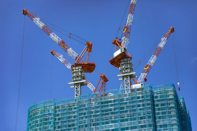 Low angle view of crane against sky