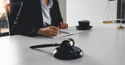 Midsection of lawyer working at desk in office