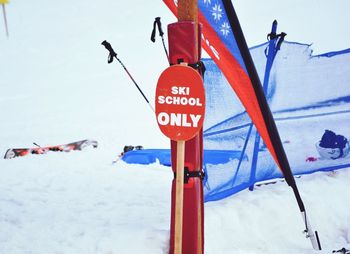 Close-up of road sign against sky during winter