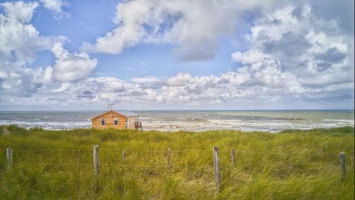 Scenic view of beach against cloudy sky