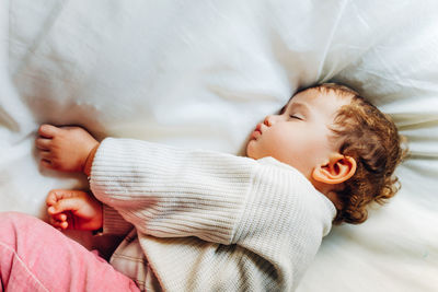 High angle view of baby girl sleeping on bed a home
