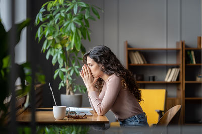 Frustrated business woman feeling worried reading email with bad news sitting at table with laptop