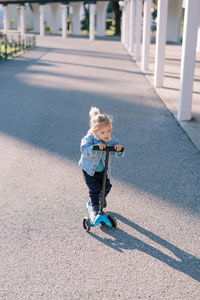 Full length of boy skateboarding on road