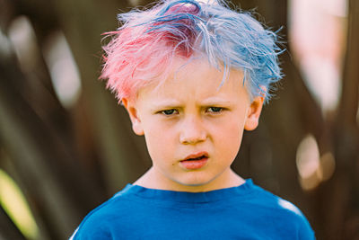 Young boy with colored hair glaring at camera