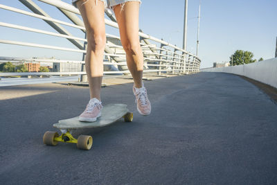 Legs of woman skating on street during sunny day