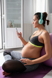 Young woman using mobile phone at home