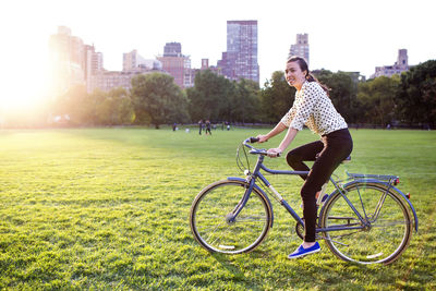 Side view of woman cycling in central park