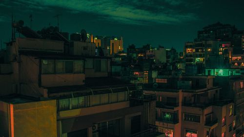 Illuminated cityscape against sky at dusk