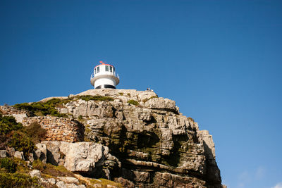 Low angle view of lighthouse against clear blue sky