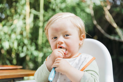 Portrait of cute boy sitting outdoors