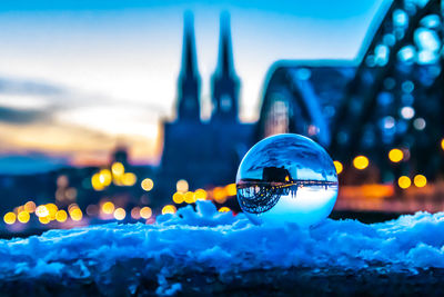 Digital composite image of illuminated ball and buildings in city