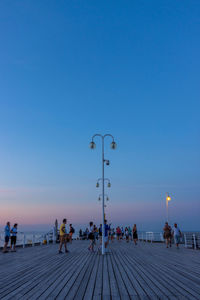 People on street against blue sky