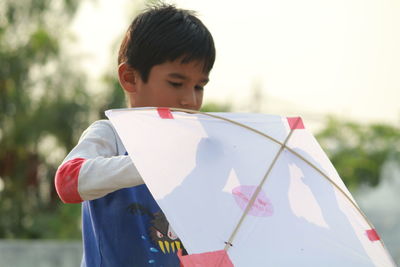 Close-up of boy holding umbrella